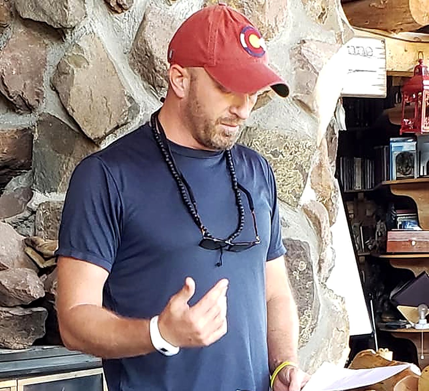 Russ reading aloud to a group by a stone fireplace