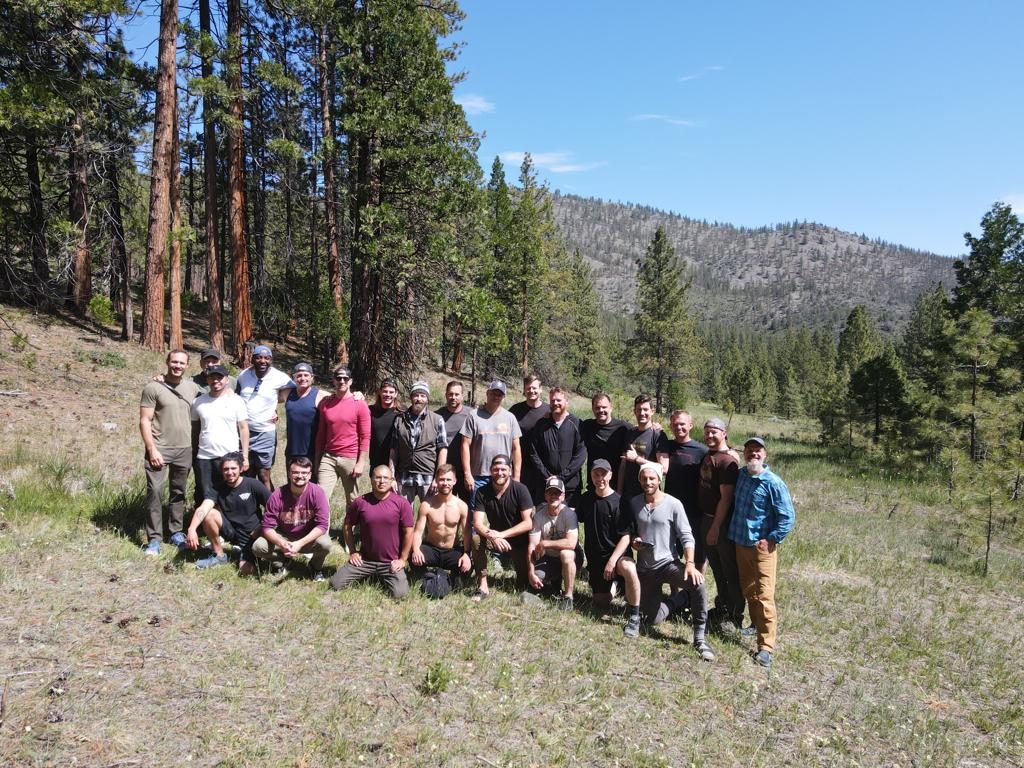 A men’s circle gathered in a mountain meadow